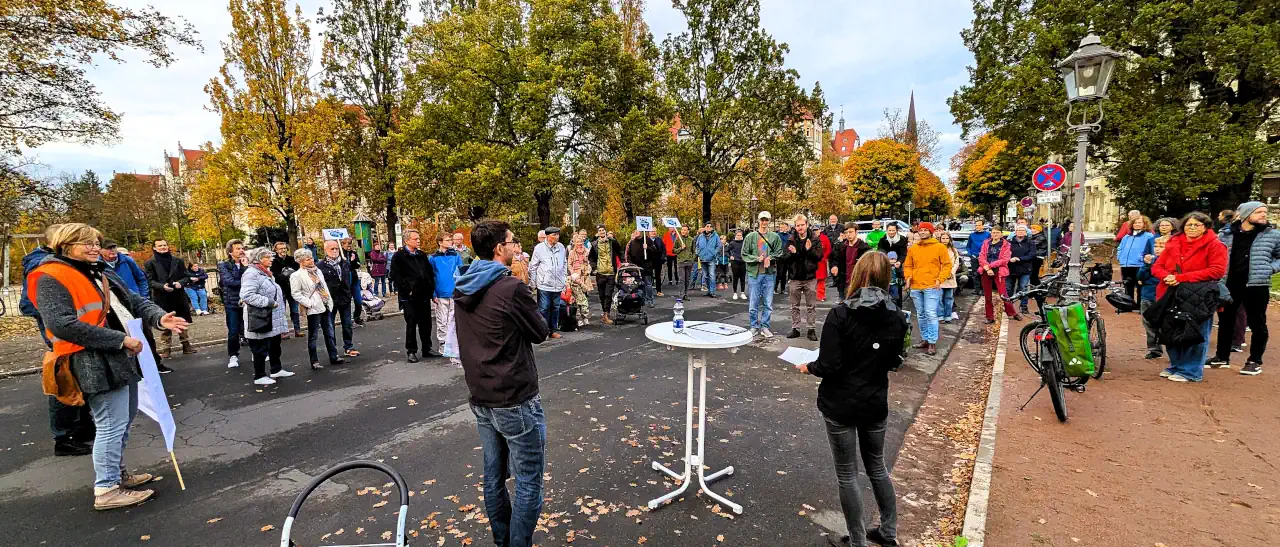 Kundgebung der Bürgerinitiative Unser Stresemannplatz im Herbst. Anwohner demonstrieren mit einem Banner ('Motorisierten Durchgangsverkehr stoppen Verkehrssicherheit stärken!') für die Verkehrswende und mehr Verkehrssicherheit am Stresemannplatz.